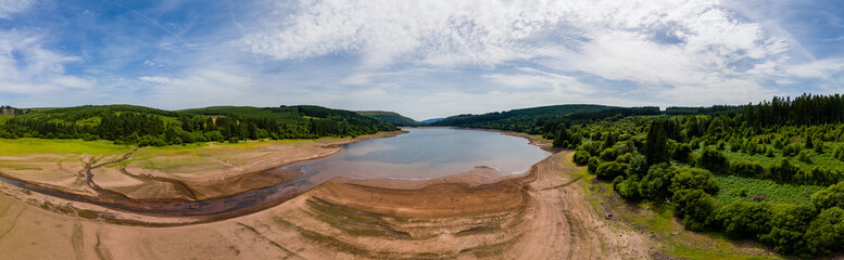 Panoramic aerial view of extremely low water levels at a reservoir during a heatwave