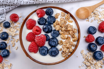 Serving yogurt with blueberry raspberry and oat flakes