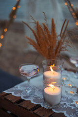 picnic in the evening at sunset on the sandy shore of the sea or ocean. decor in boho and rustic style.