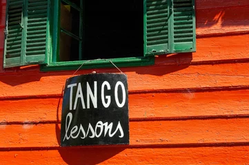 Zelfklevend Fotobehang "TANGO lessons" sign hanging from an old wooden window in "La Boca" Neighborhood, Argentina © Emanuele Pasin/Wirestock Creators
