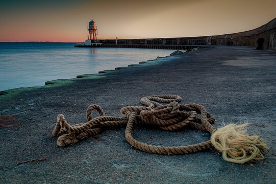 Rope at the coast on the background of a lighthouse during sunset near Helsingborg, Sweden