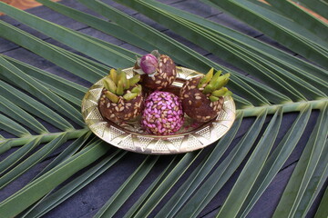 Healthy date fruit energy bliss balls with sesame seed on palm background