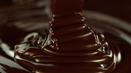 Close-up of pouring stream of melted chocolate.