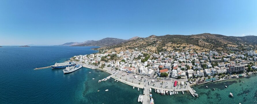 Wide-angle shot of the Marmari coast harbor during daytime with a clear blue sky, Greece