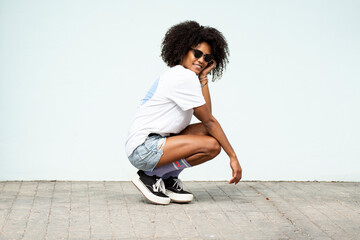 Happy young hipster woman with afro hairstyle and fashionable clothes posing outdoor. Good vibes...