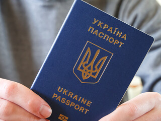 Ukrainian passport in the hand of its owner in close-up.