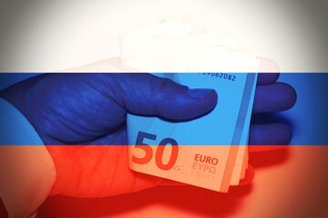 Business man hand while handing money with the Russian Flag as background, concept of corruption .