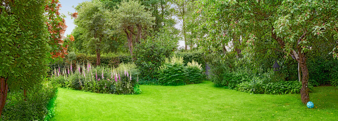 A beautiful nature view of green grass, plants, trees, and flowers. Private outdoor park lawn...