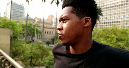 Pensive black man standing in urban downtown city