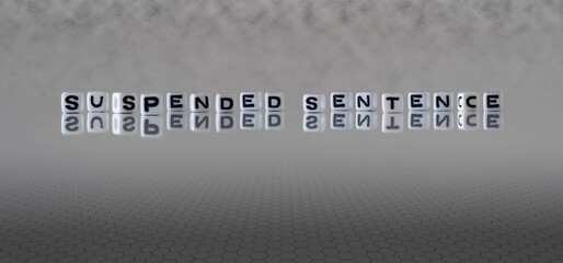 suspended sentence word or concept represented by black and white letter cubes on a grey horizon background stretching to infinity - obrazy, fototapety, plakaty