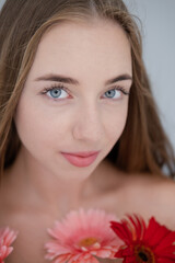 Portrait of pretty young woman with pink and red chrysanthemum flowers