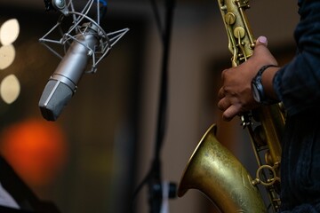 Closeup shot of a person playing a saxophone in a musical studio