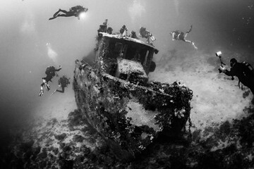 Group of divers exploring sunken ship. Wreck diving on Madagascar