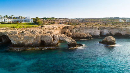 Aerial bird's eye view of Love bridge, international sculpture park and sea caves, at Cavo Greco, Ayia Napa, Famagusta, Cyprus from above. Tourist attraction cliff rock arch in Ammochostos from above.