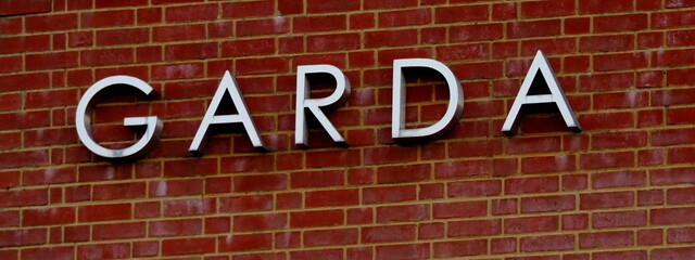 Garda sign on building with red brick