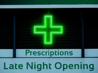 Pharmacy late night opening with green neon cross