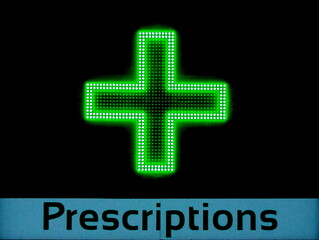 Fototapeta premium Pharmacy prescriptions with green neon cross on chemist shop building