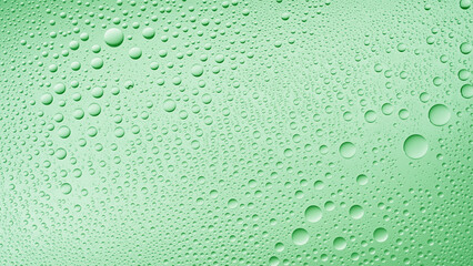 Water drops on wet glass surface on green background | Background for skin care moisturizing products