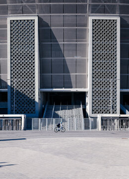 Vertical shot of a biker with Ferenc Puskas Stadium on the background in Hungary