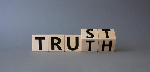 Trust and Truth symbol. Turned cubes with words Truth and Trust. Beautiful grey background. Business and Trust and Truth concept. Copy space