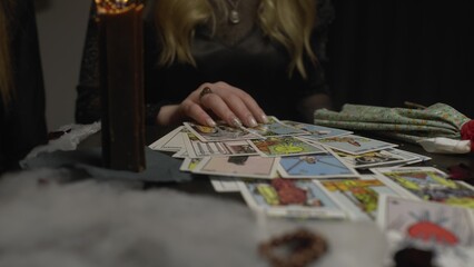 4K. A witch woman in a dark room reading tarot cards