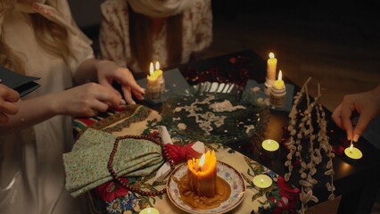 4K. Slavic women are guessing with a ring in a dark room by candlelight