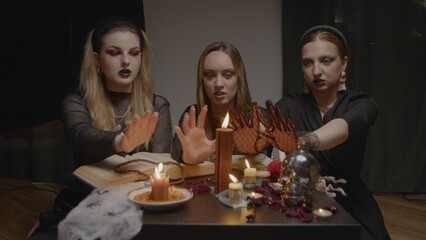 4K. Three female witches in a dark room conduct mystical sessions