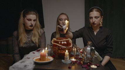 4K. Three female witches in a dark room conduct mystical sessions