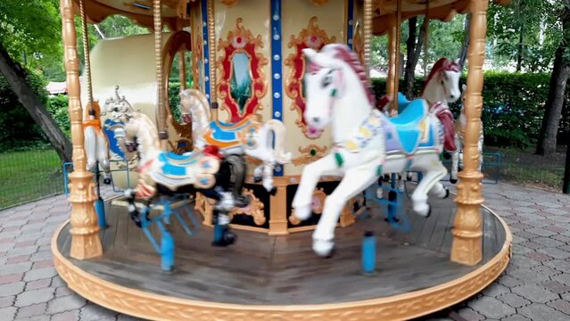 Carousel with horses in the amusement park. Leisure activities. Entertainment for children on holiday. Video..