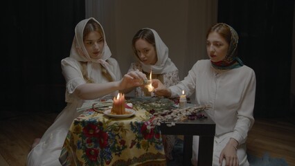 4K. Slavic women are guessing with a ring in a dark room by candlelight