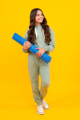 Teenage girl in track suit, fashion sports wear isolated on yellow background. Fitness sport child...
