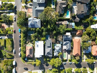 Aerial drone view of a street, houses, and parked cars in the suburbs of Sydney