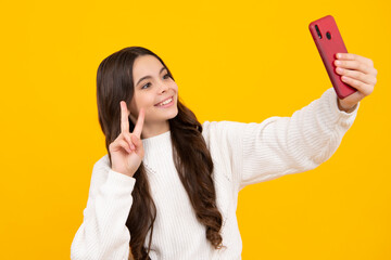 Kids selfie. Mobile online shopping. Cute teen child girl paying with phone, texting and chatting on smartphone. Happy face, positive and smiling emotions of teenager girl.
