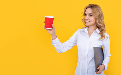 happy blonde woman with coffee cup and computer on yellow background