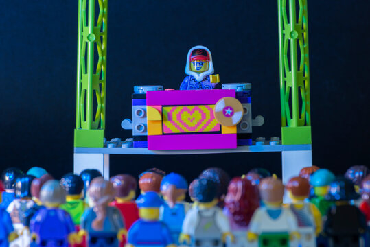 Lego DJ minifigure performing a show on stage with thousands of spectators