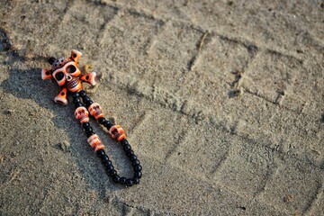 Closeup of pirate bracelet with skulls on sandy ground