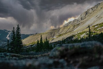 Beautiful shot of a mountainous landscape with gloomy grey clouds in the sky - Powered by Adobe