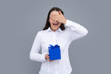 Portrait of a happy girl with gift box isolated over gray background. Woman holding gift present.