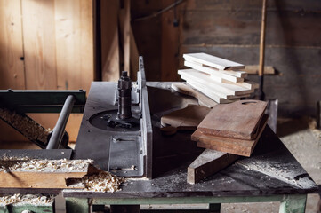 carpenter's workbench with many different wood blanks and planks of wood.  rustic old carpenter's workshop.