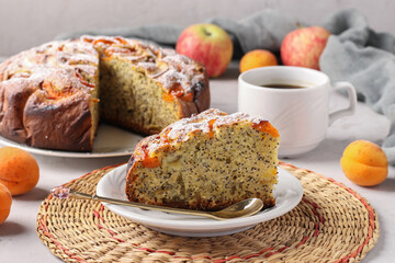 Homemade apricots pie with poppy seeds and apples, with cup of coffee on light gray background