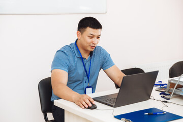 an Asian man is working at a computer .the student is studying, studying online.business concept of technological devices