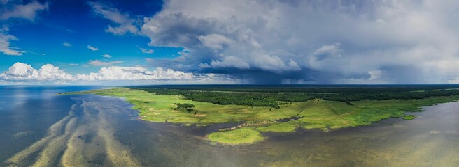 Aerial panoramic view on the coastal wetland with rain cloudedsky on the background