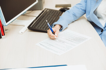 A young woman is talking to a client on the phone in the office.a woman in a business suit works in an office