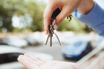 a realtor woman holds the key to an apartment in a new house, the owner of the property, makes a sale, buys the concept of a real estate transaction, close-up