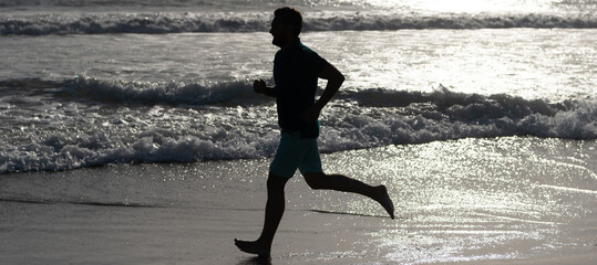 Man running and jumping, banner with copy space. athlete run fast to win in the ocean. morning...