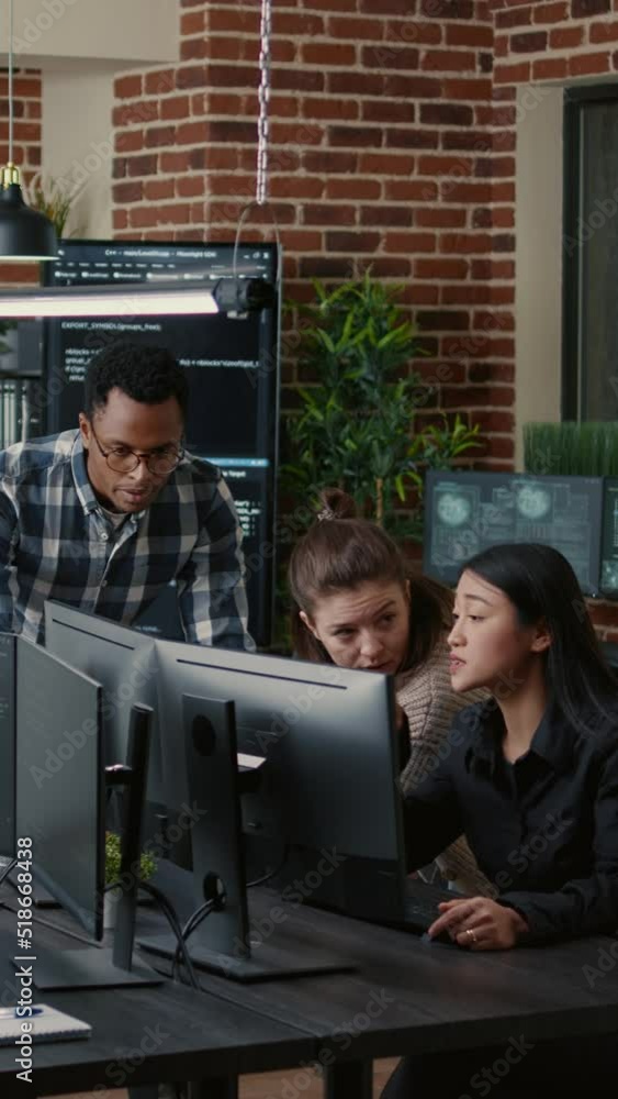 Poster vertical video software engineers brainstorming ideas looking at code on computer screens asking fee