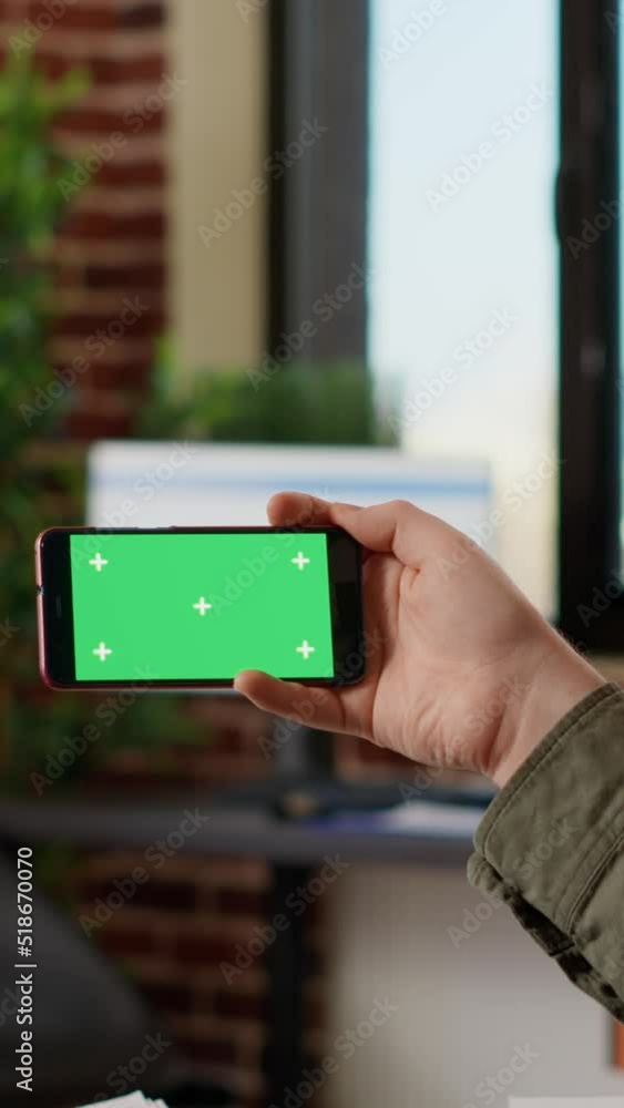 Aufkleber vertical video: office employee looking at horizontal greenscreen on smartphone, analyzing isolated 