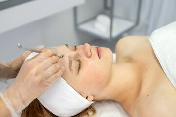 Obraz na płótnie Canvas Teen girl performs salon cosmetology procedure on her face