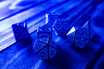 RPG dice illuminated with colored light, light painting style photo, selective focus.