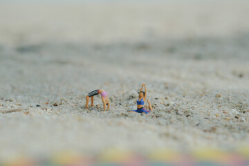 miniature people comes into a stunning big toe bow pose, yoga on the beach use for background 